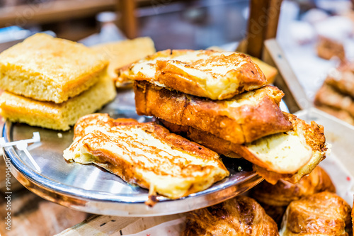 Closeup pile stack of many french toast savory sweet egg bread slices fried on serving tray in home bakery shop, store, cafe