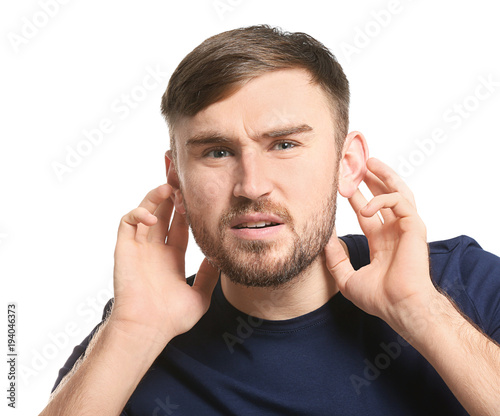 Young man with hearing problem on white background