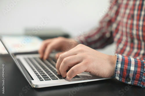 Young man with laptop working in office