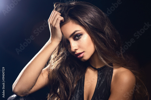 Fashion beauty trend portrait of beautiful brunette girl with long and shiny curly hair. Sexy baby faced model woman with curls hairstyle. Care and beauty of hair