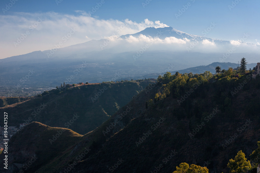 Etna Volcano and hills in the fron in backlight from Taormina in Sicily, Italy