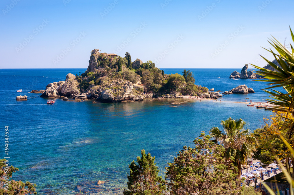 The Isola Bella island with the beach, excursion boats and bathers in Taormina, Italy
