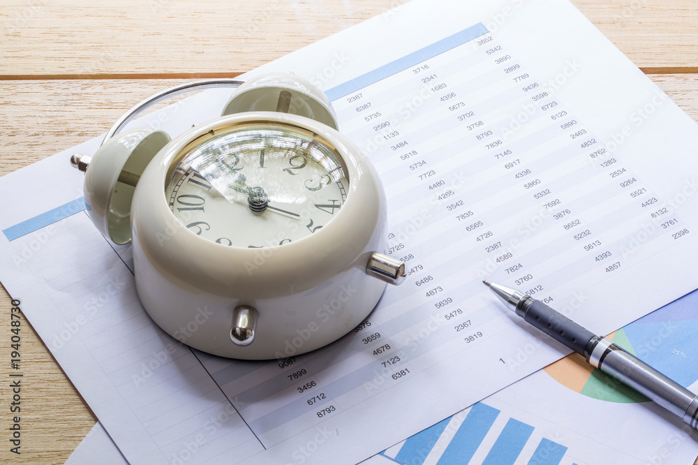 clock, files and pen on a market report clock, files and pen on a market report