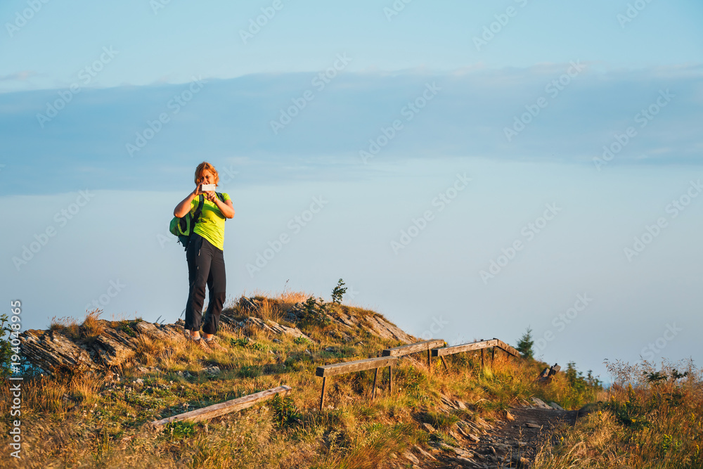Obraz premium woman stands on the top and admires the beautiful sunrise