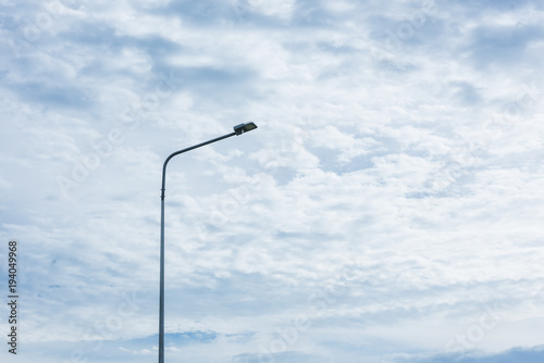 street lamp pole light against the white clouds sky