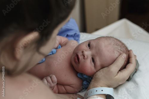 Mother looking at newborn baby in hospital photo