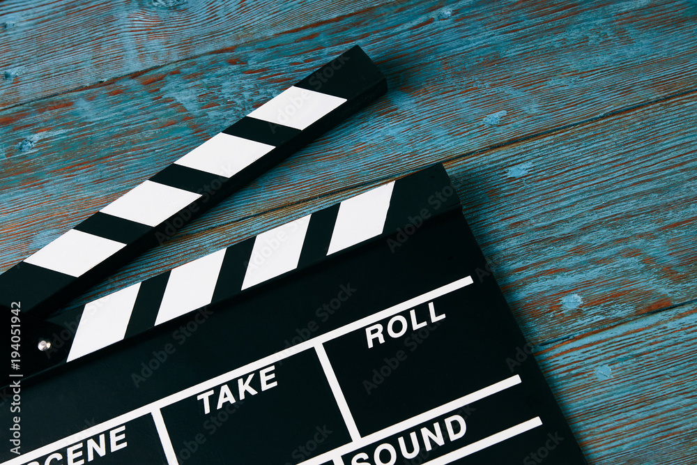 Obraz premium Movie clapper board. Black clapperboard on blue wooden background with copy space, close-up. Cinema and movie time concept