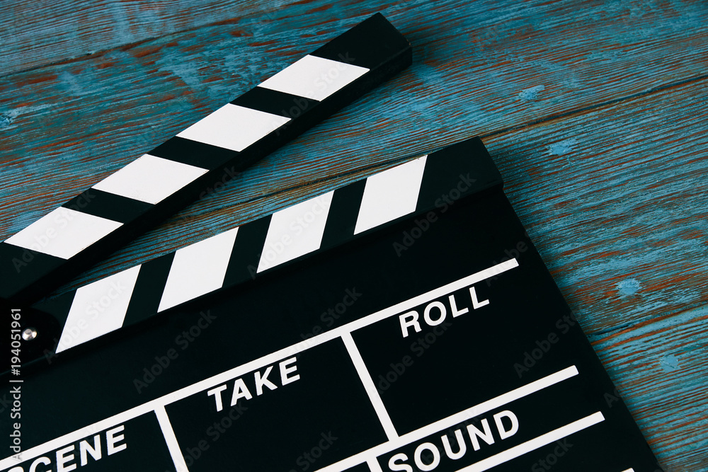 Obraz premium Movie clapper board. Black clapperboard on blue wooden background with copy space, close-up. Cinema and movie time concept
