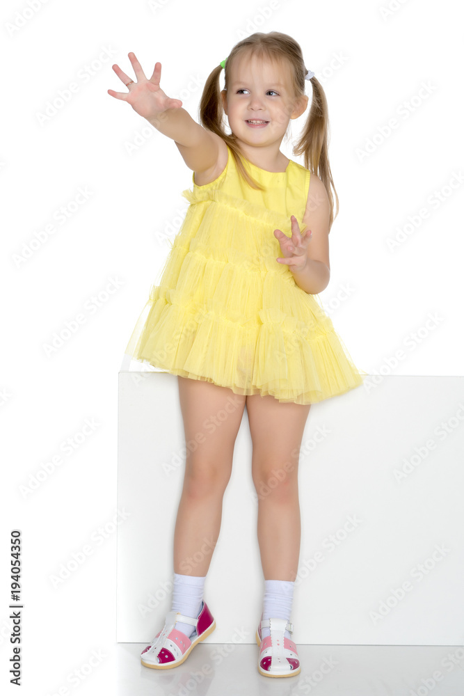 Fototapeta premium A little girl is looking from behind an empty banner.