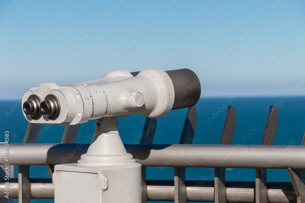 White binoculars staring at clear blue sea horizon White binoculars staring at clear blue sea horizon