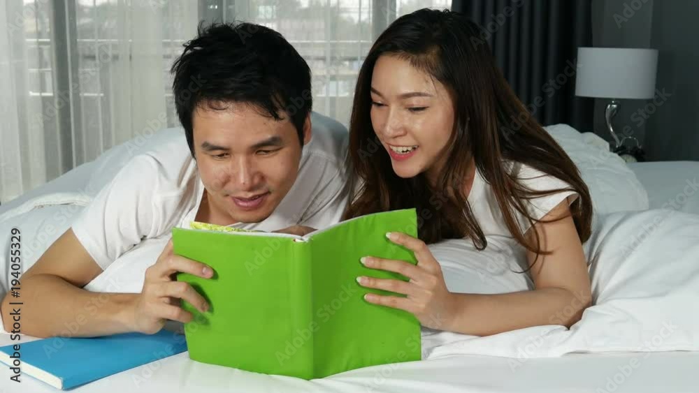 4k of young couple reading a book on bed in the bedroom 4k of young couple reading a book on bed in the bedroom