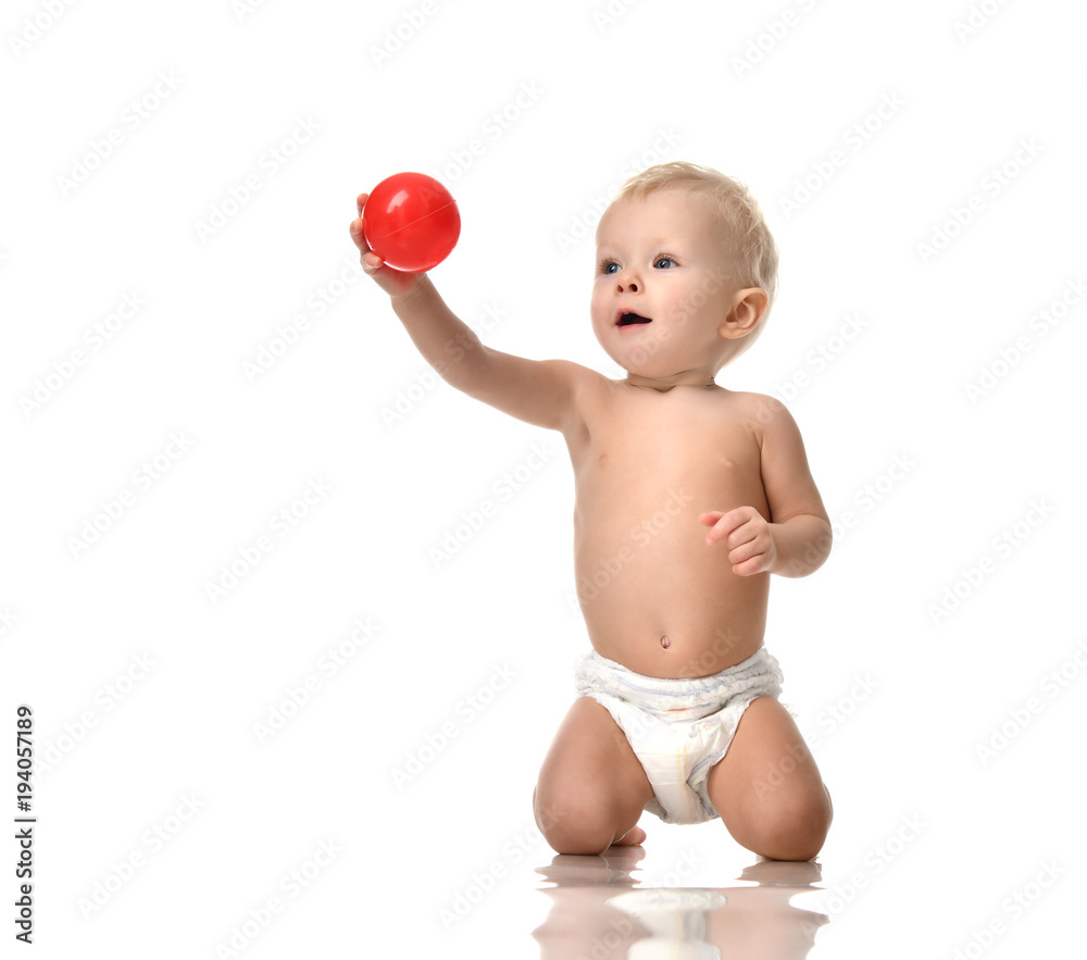 Infant child baby toddler sitting naked in diaper and play with red ball isolated Infant child baby toddler sitting naked in diaper and play with red ball isolated