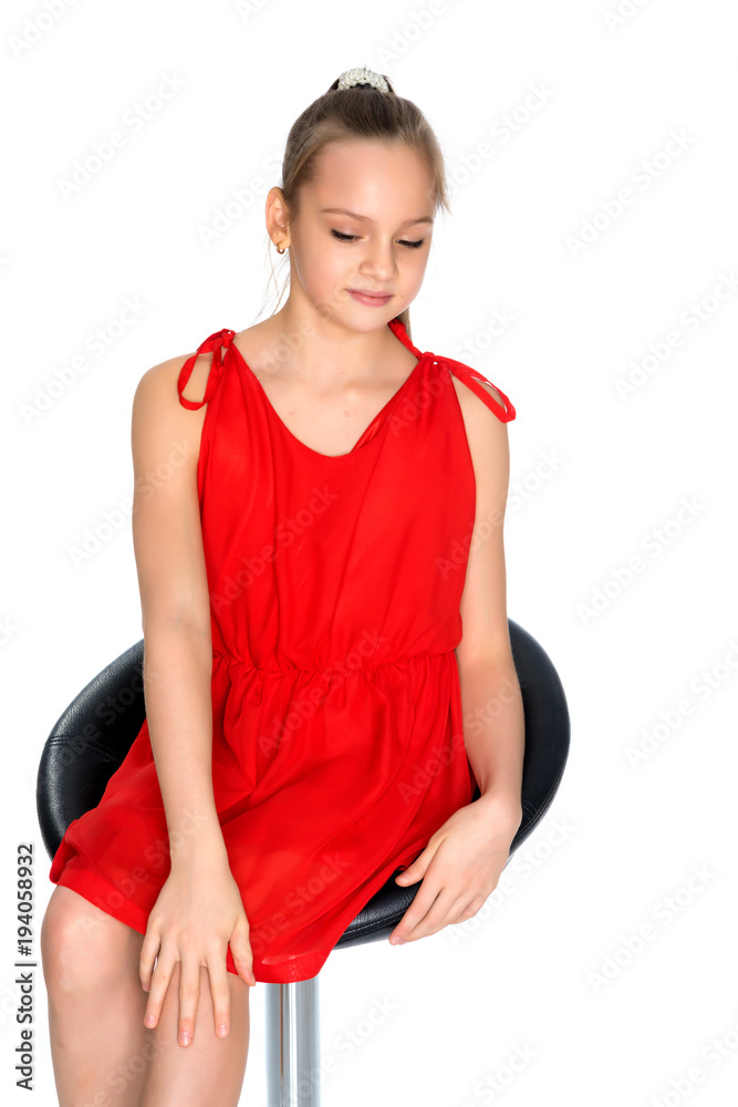 A teenage girl is sitting on a chair. A teenage girl is sitting on a chair.