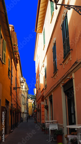 Narrow street with flowers in the old town of Alassio, western Liguria. Italy