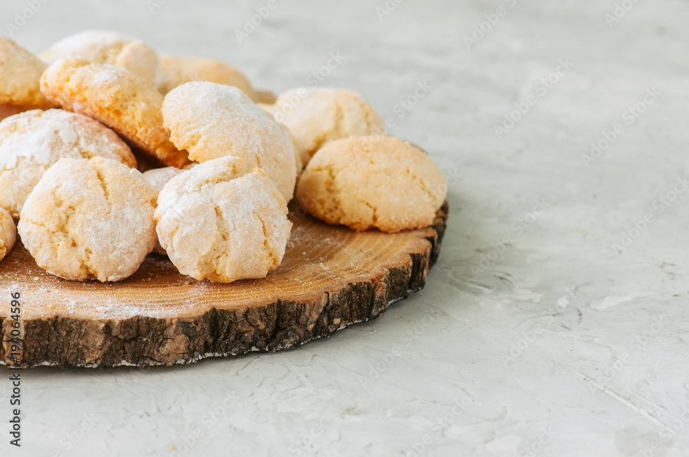 Homemade amaretti cookies on a wooden board on a white stone backdrop. Homemade amaretti cookies on a wooden board on a white stone backdrop.