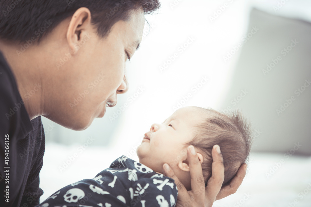 Proud asian father holding his newborn baby at home. Proud asian father holding his newborn baby at home.