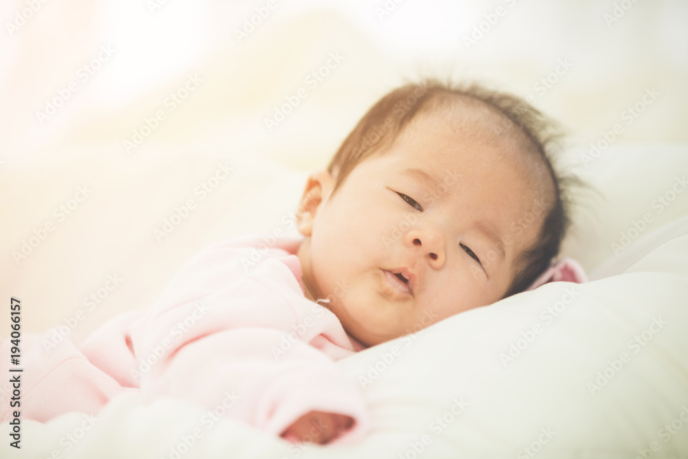 Baby sleeping in bed and looking camera ,