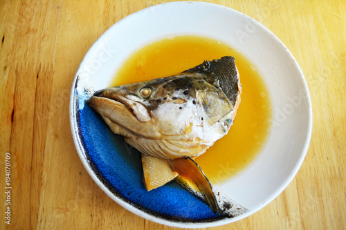 Salmon Kabutoni or Salmon head with sweet sauce on the white dish for japanese food background photo