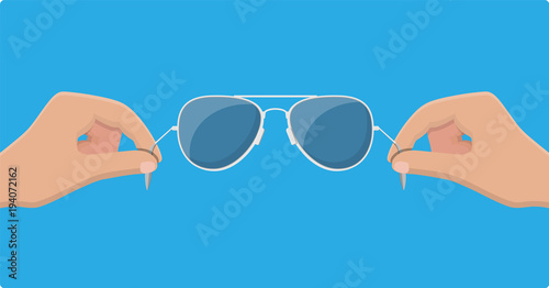 Aviator sunglasses in hand. Protective eyewear.