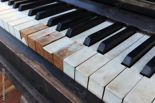 Detail of old, broken and dusty piano claviature photo