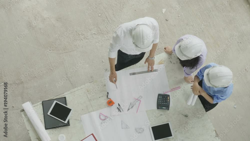 Top view of architect and engineer brainstorming at a construction site.
