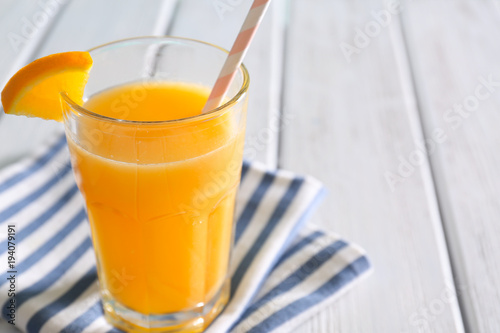 Glass with fresh orange juice on wooden table, closeup
