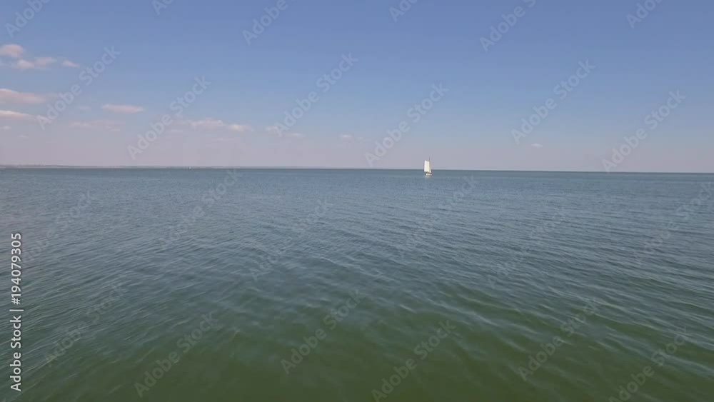 A sailing ship is in the calm waves of the ocean in calm weather A sailing ship is in the calm waves of the ocean in calm weather