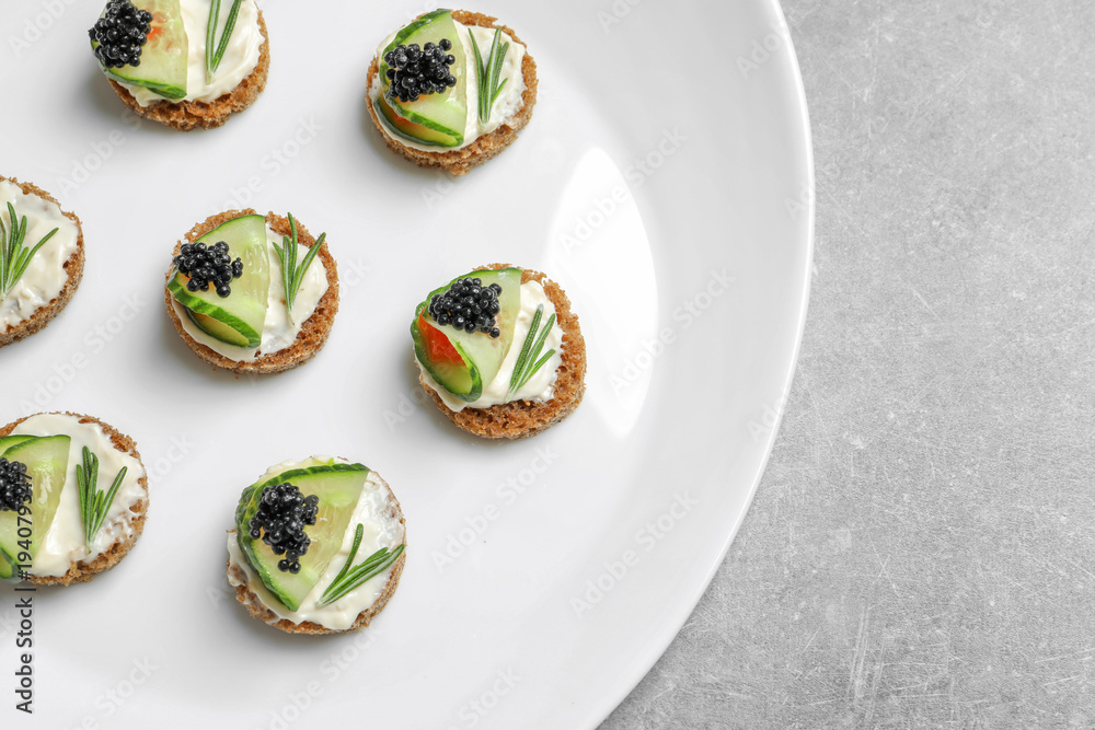 Tasty appetizer with black caviar and cucumber on plate Tasty appetizer with black caviar and cucumber on plate