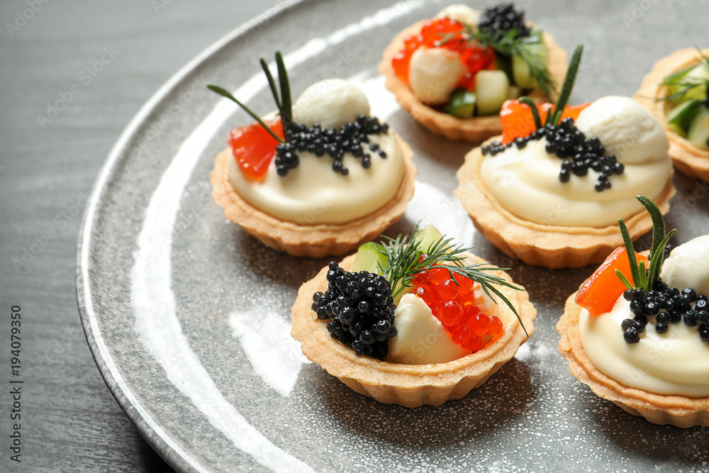 Tasty black caviar appetizers on plate