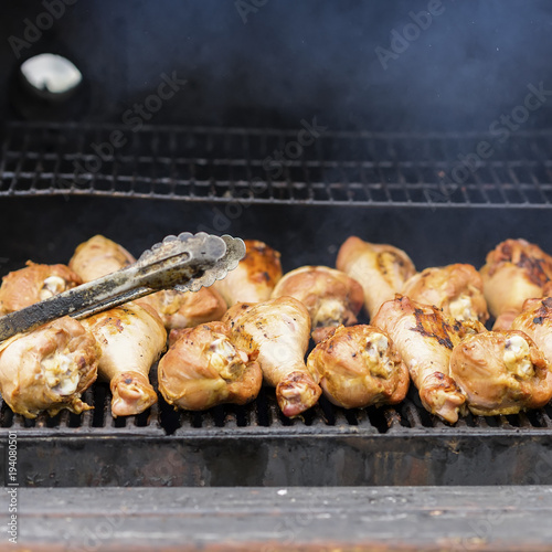 Appetizing turkey drumsticks on the grill, on charcoal stove with fire and smoke close-up . Concept summer picnic, nutrition, diet