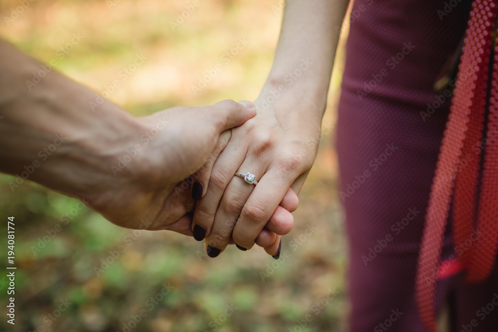 guy with girl engagement ring hands flowers