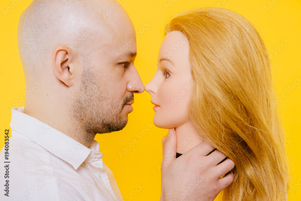 Excited odd bizarre strange unusual adult bald hairless man holding plastic  blonde woman head. Funny male with girlfriend isolated on yellow. Baldness  after chemotherapy. Cancer hair loss concept. Stock Photo | Adobe