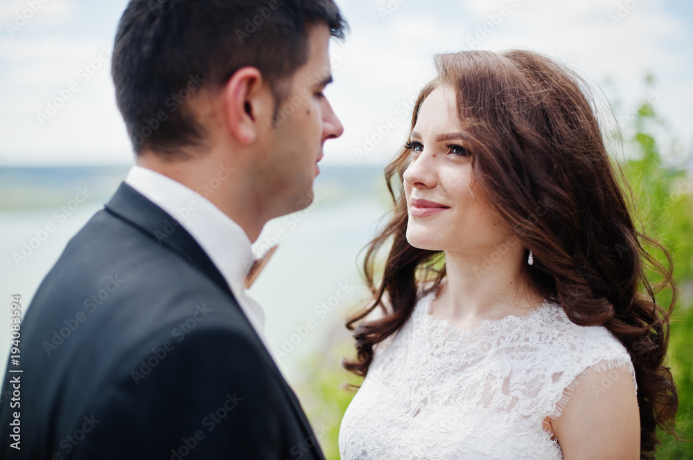 Wedding couple at breathtaking landscape with rock and lake. Wedding couple at breathtaking landscape with rock and lake.