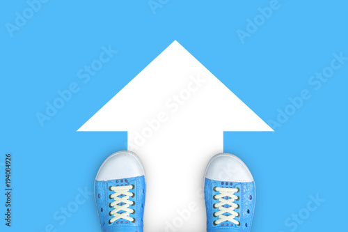 Minimal concept of going forward. Blue shoes standing on blue floor and go ahead forward sign on the floor