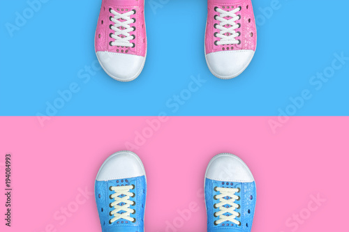 Minimal concept of life. Blue and pink shoes standing on different floor. Think different, opposite, rival, enemy