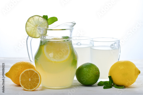 Citrus lemonade and lime water with lemon sliced , healthy and detox water drink in summer on white wooden table