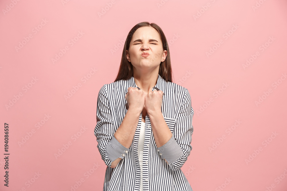 Obraz premium Portrait of an angry woman looking at camera isolated on a pink background