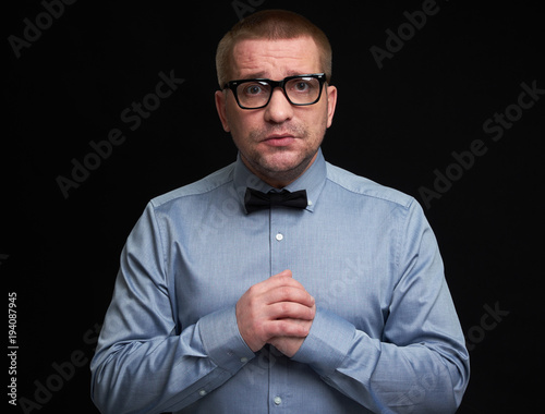 miserable man wearing glasses and bow tie