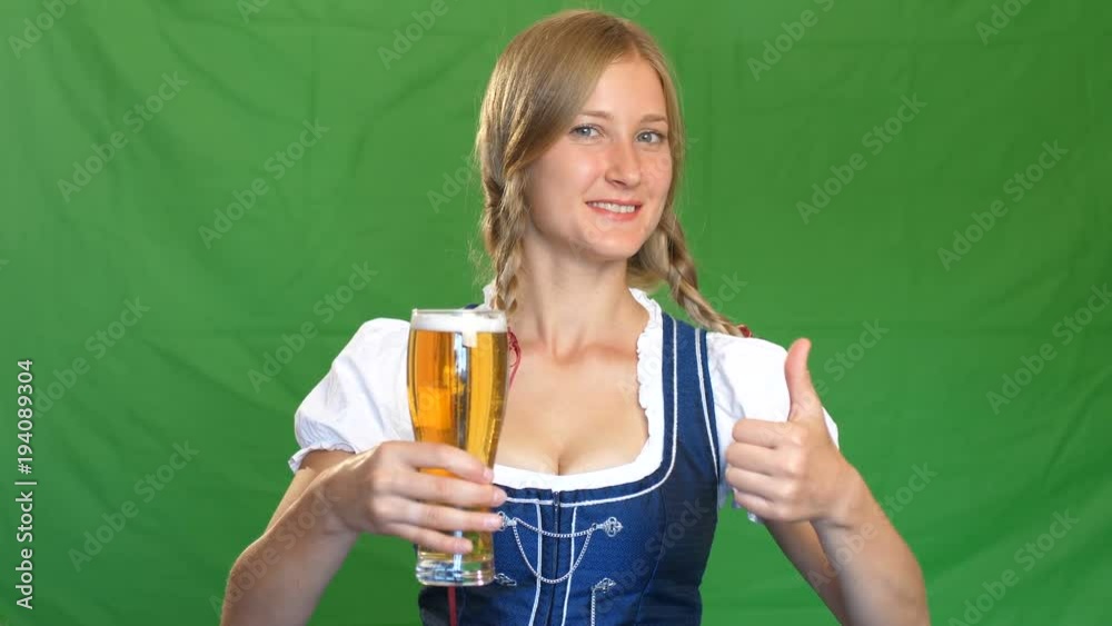 Woman in bavarian costume laughs and shows thumbs up. Green screen Woman in bavarian costume laughs and shows thumbs up. Green screen