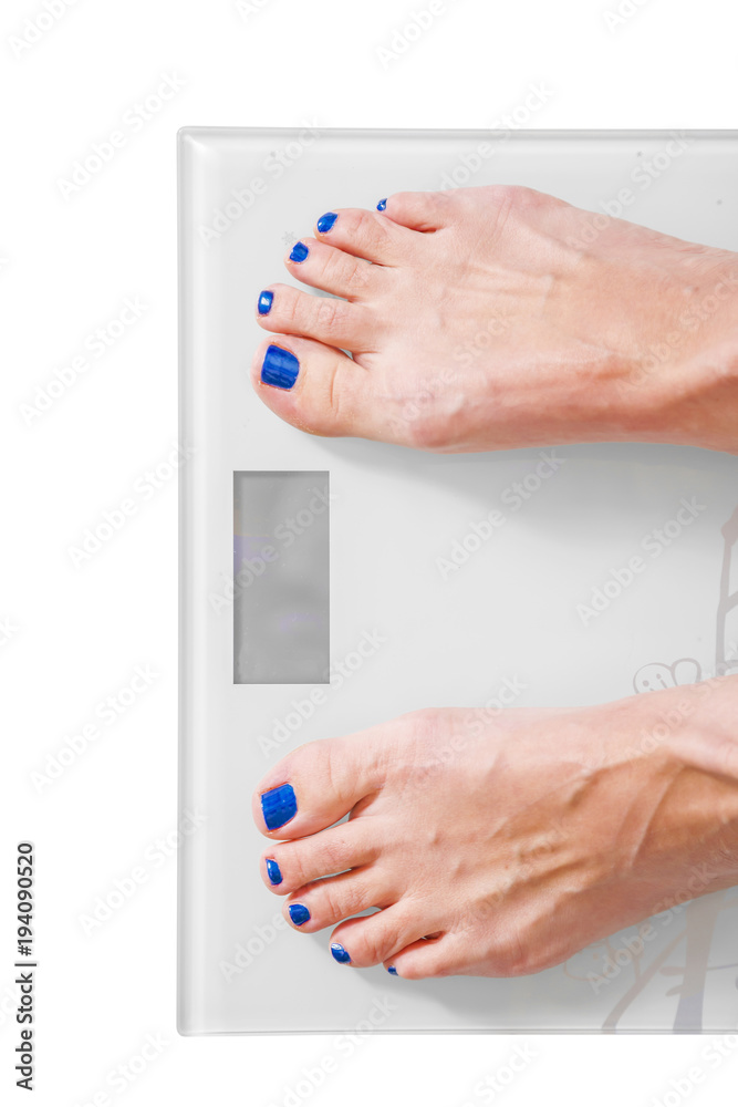 Female feet on personal scales - obesity and diet concept Female feet on personal scales - obesity and diet concept