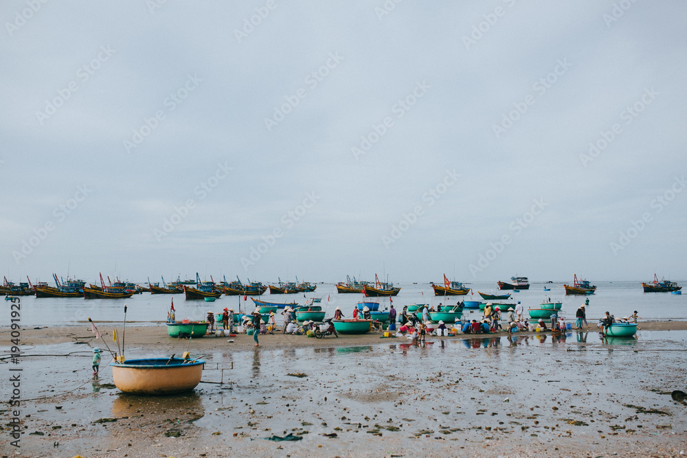 MUI NE, VIETNAM - 03 JANUARY, 2018: vietnamese fishermen with seafood on sandy beach at Mui Ne, Vietnam MUI NE, VIETNAM - 03 JANUARY, 2018: vietnamese fishermen with seafood on sandy beach at Mui Ne, Vietnam