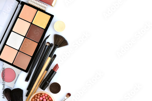 Makeup brush and decorative cosmetics on a white background. Top view. Space for text