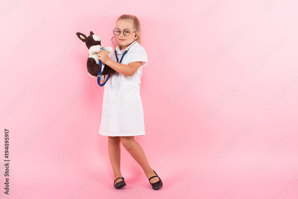 Little girl in doctor costume with toy Little girl in doctor costume with toy