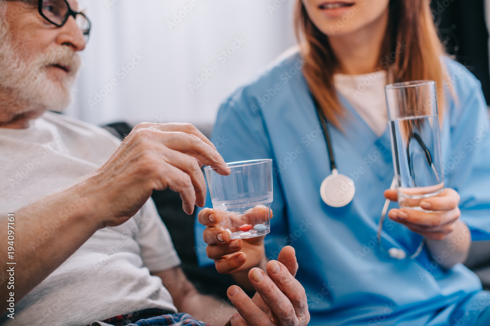 Female nurse giving pills to senior patient Female nurse giving pills to senior patient