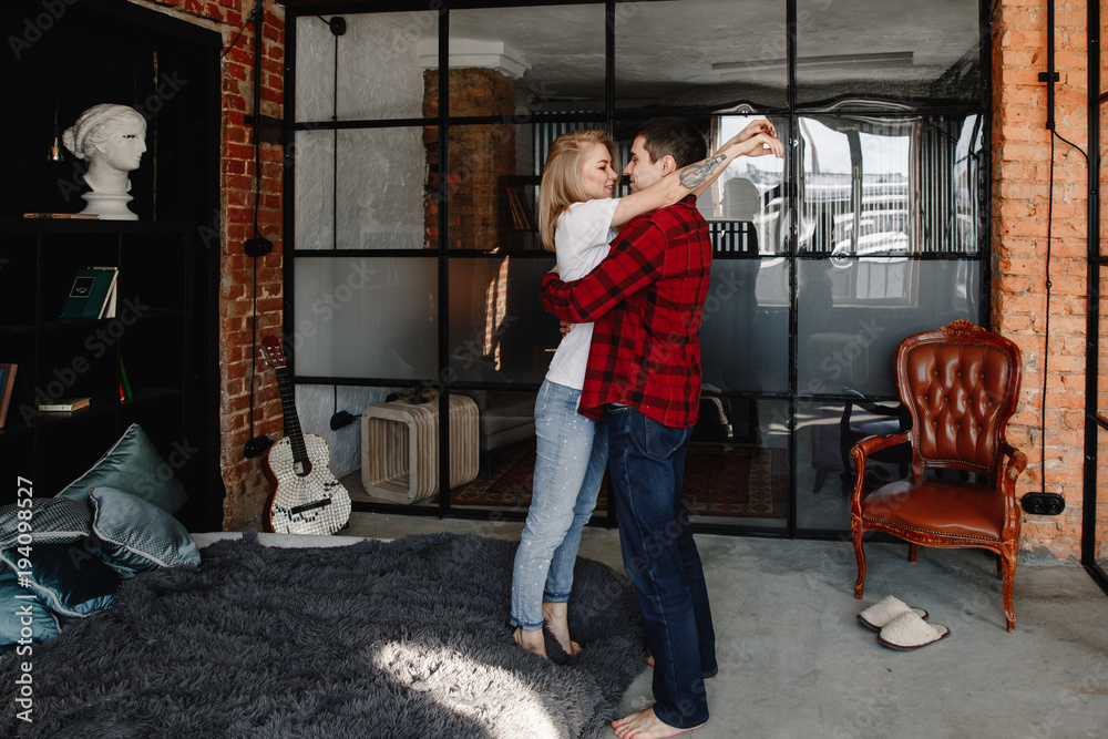 Fototapeta premium stylish young couple having fun in cozy bedroom in style loft, feeling happy being together.