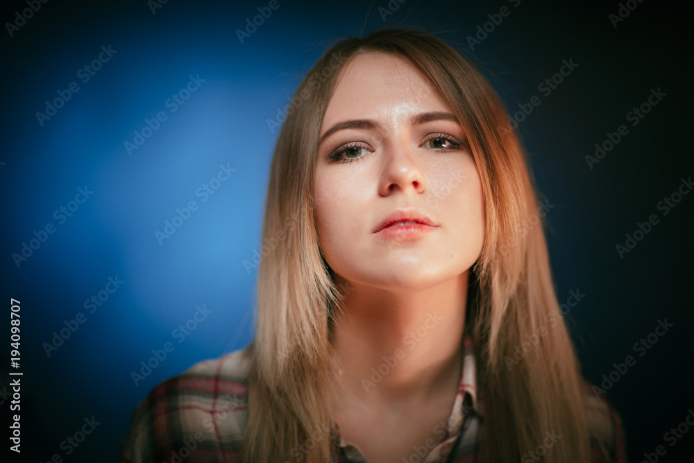 portrait smiling girl on blue background in studio