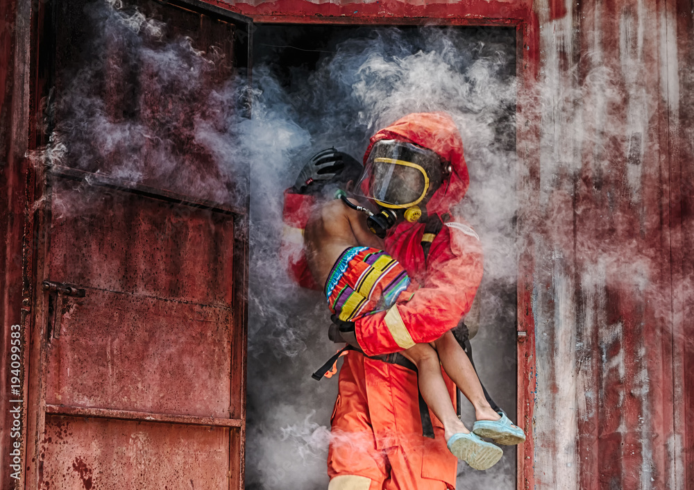 Fototapeta premium Emergency Fire Rescue training,Firefighters save the boy from burnt place
