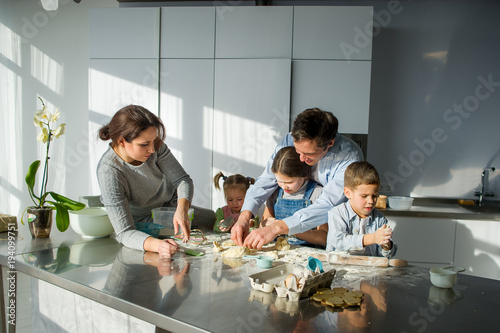 Large family prepares something of dough.