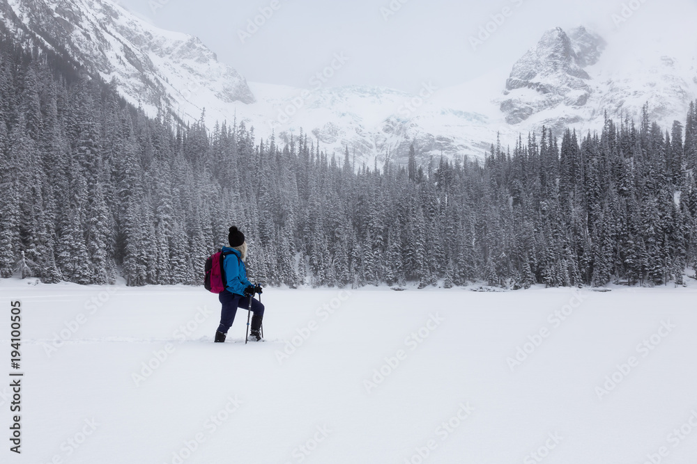 Adventurous girl snowshoeing in Joffre Lake, British Columbia, Canada.