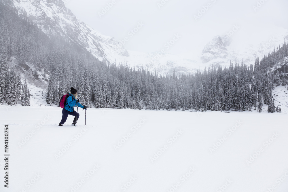 Adventurous girl snowshoeing in Joffre Lake, British Columbia, Canada.